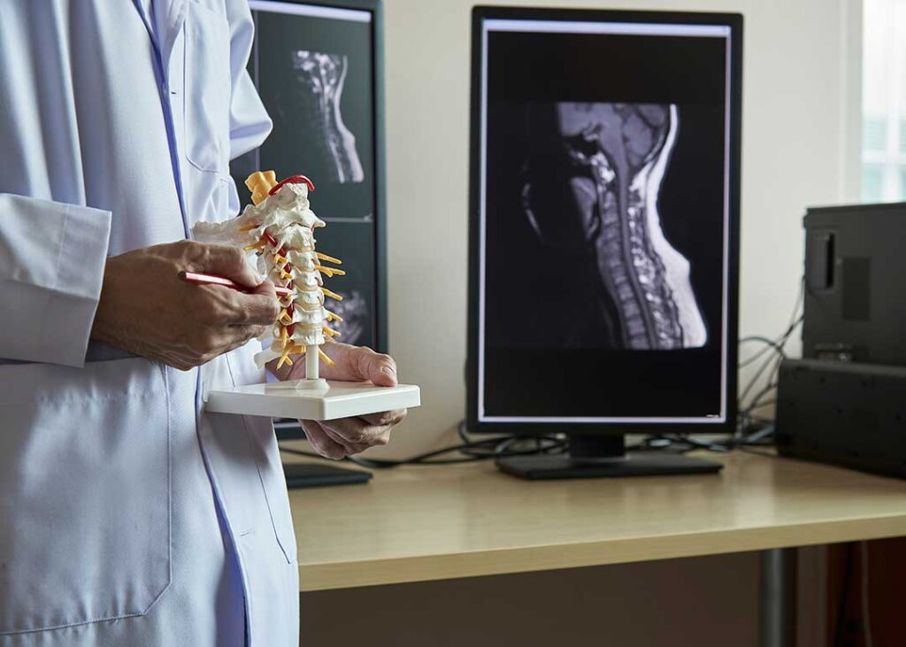 A middle-aged person gently stretching their neck and shoulder while seated in a living room.